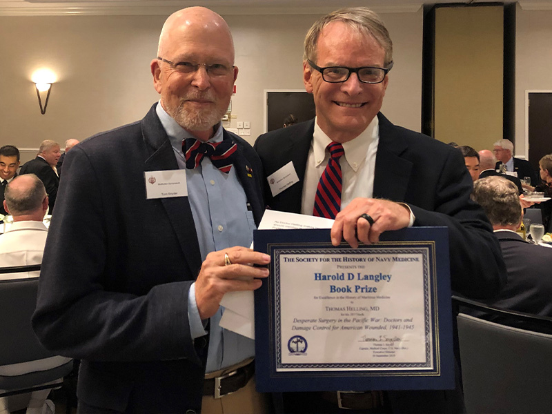 Thomas L Snyder, left, retired U.S. Navy Medical Corps and executive director of the Society for the History of Navy Medicine, presents the 2019 Harold D Langley Book Prize for Excellence in the History of Maritime Medicine to Dr. Thomas Helling.